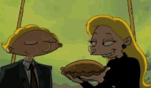 a man in a suit and tie is giving a pie to a woman with blonde hair