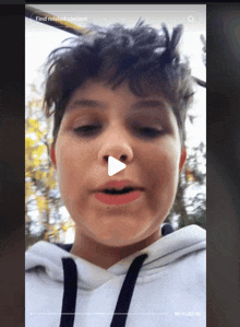 a video of a young boy with a play button on his nose