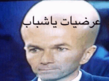 a man with a big bald head has arabic writing on his head