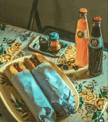 two hot dogs on a plate next to a bottle of soda