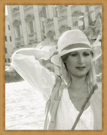 a woman wearing a white hat is standing in front of a body of water