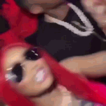 a blurry picture of a man and a woman with red hair and sunglasses