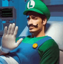 a man in a hospital bed dressed as luigi from super mario is waving his hand .