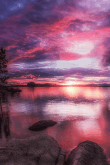 a sunset over a lake with a purple sky