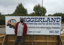 a man is standing in front of a sign that says ' iggerland ' on it