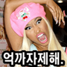 nicki minaj is wearing a pink hat with a cherry on it .