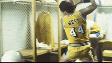 a basketball player wearing a yellow jersey with west 44 on the back