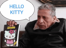 a man holds a hello kitty book in his hand