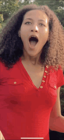 a woman in a red shirt has her mouth open