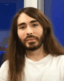 a man with long hair and a beard is wearing a white t-shirt