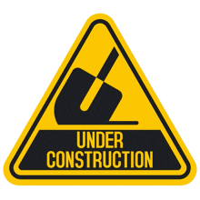 a yellow sign that says under construction with a shovel on it