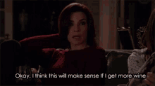 a woman is sitting on a couch with a glass of wine .