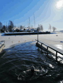 a person is swimming in a body of water with a sign in the background that says ' ice '