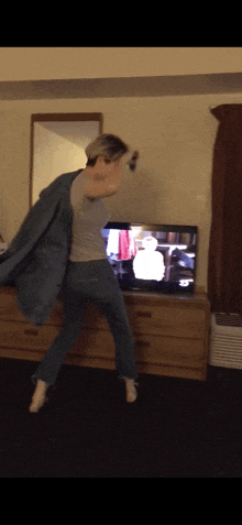 a person is dancing in front of a television