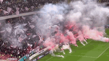 a soccer field with smoke coming out of the stands and a sign that says " culestem " on it