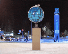 a statue of a globe stands in front of a sign that says ' aekect ' on it