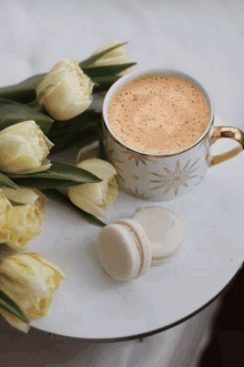 a cup of coffee sits next to a bouquet of flowers