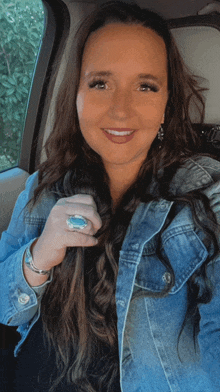 a woman wearing a denim jacket and a turquoise ring