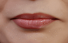 a close up of a woman 's lips with water drops