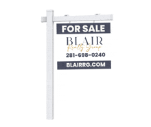 a for sale sign for blair realty group is on a white pole