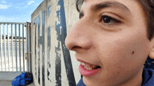 a close up of a person 's face with a fence in the background that says a