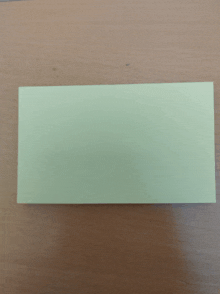 a rectangular piece of paper is on a wooden table