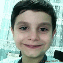 a young boy is smiling for the camera while taking a selfie .