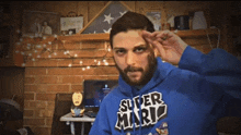 a man with a beard wears a blue super mario sweatshirt