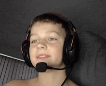 a young boy wearing headphones with a microphone attached to his neck