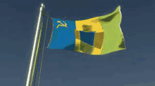 a blue yellow and green flag with a yellow hammer and sickle on it