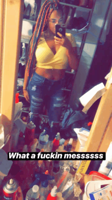 a woman taking a selfie in front of a mirror with the words what a fuckin messssss below her