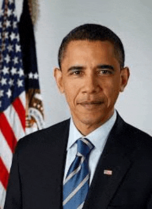 barack obama is wearing a suit and tie and posing in front of an american flag .