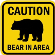 a yellow caution sign with a black bear on it