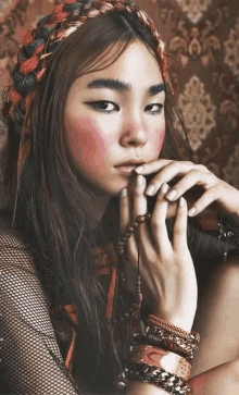 a woman wearing a braided headband and many bracelets