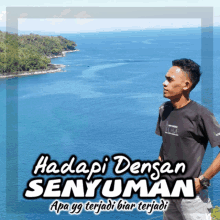 a man in a black shirt stands in front of a body of water with the words hadapi densan senyuman