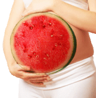 a pregnant woman is holding a slice of watermelon in her hands