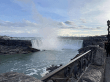 a waterfall is surrounded by a wrought iron fence