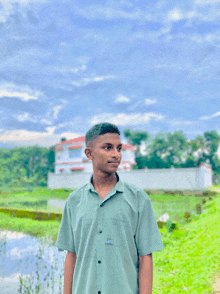 a young man in a green shirt stands in front of a building