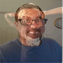 a man wearing glasses and a blue shirt has a reflection of his face in a glass