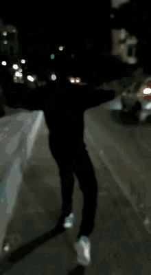 a blurry picture of a person walking down a street at night