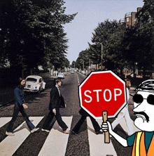 a man holding a stop sign in front of the beatles