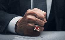 a man is wearing a ring with a flag on it