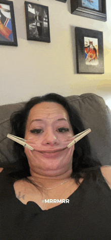 a woman is laying on a couch with a pair of clips in her mouth and the hashtag #mrrmrr