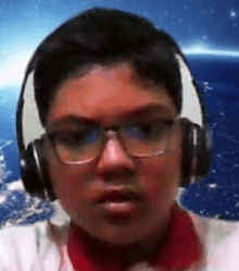 a boy wearing headphones and glasses is looking at the camera .