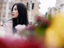 a woman in a white jacket stands in front of a blurry background