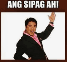 a man in a suit and pink shirt is waving his hand and says ang sipag ah !