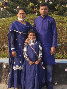 a family poses for a picture in front of a tree