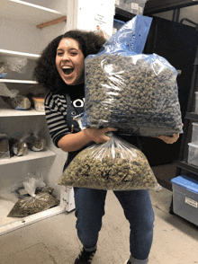 a woman is holding a bag of marijuana with the numbers 2 and 3 on it