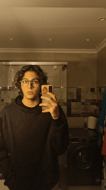 a young man taking a selfie in a bathroom