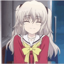 a girl in a school uniform with a bow on her neck is smiling .